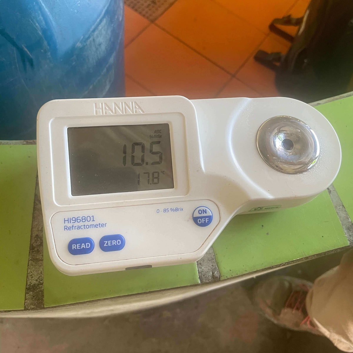 Digital refractometer on a green surface with a blurred background